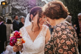 Immagine del matrimonio di Var: testa a testa con grandi sorrisi, in piedi insieme alla madre della sposa in un toccante momento del matrimonio.